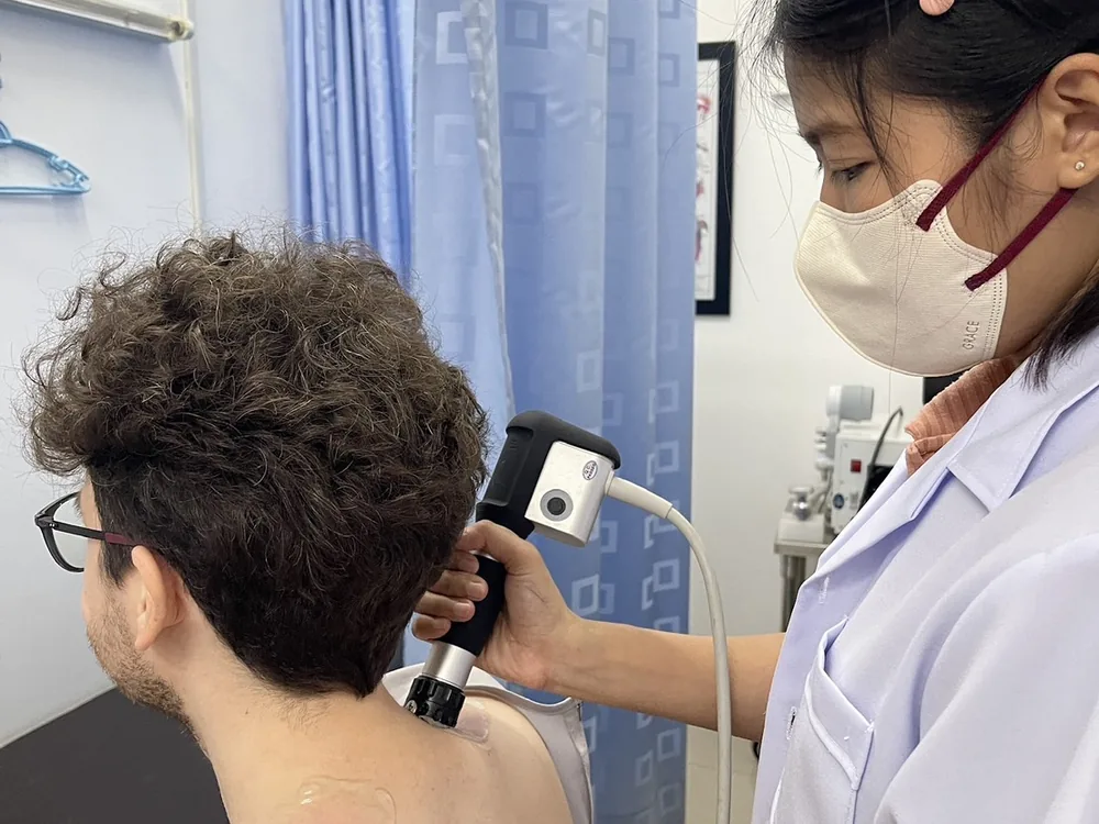 นักกายภาพบำบัดกำลังใช้เครื่อง Radial Shockwave บริเวณคอและบ่าภายในคลินิก